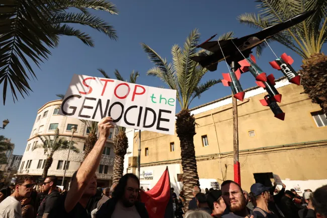 Ισραηλινοί Άραβες και Εβραίοι ακτιβιστές υπέρ της ειρήνης συμμετέχουν σε διαμαρτυρία στην πόλη Χάιφα με αίτημα τον τερματισμό του πολέμου. Κρατούν πλακάτ «Σταματήστε τη γενοκτονία»