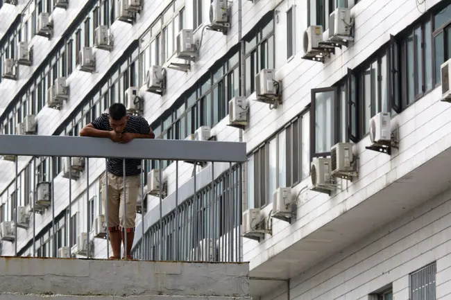 Πολίτης μπροστά από μία σειρά κλιματιστικών.