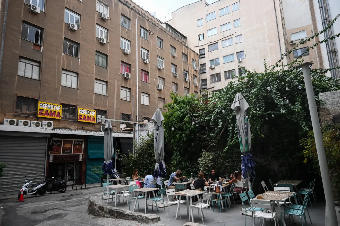 Τρεις παρέες κάνουν το γεύμα τους σε ένα από τα εναπομείναντα ανοιχτά εστιατόρια της Αθήνας.