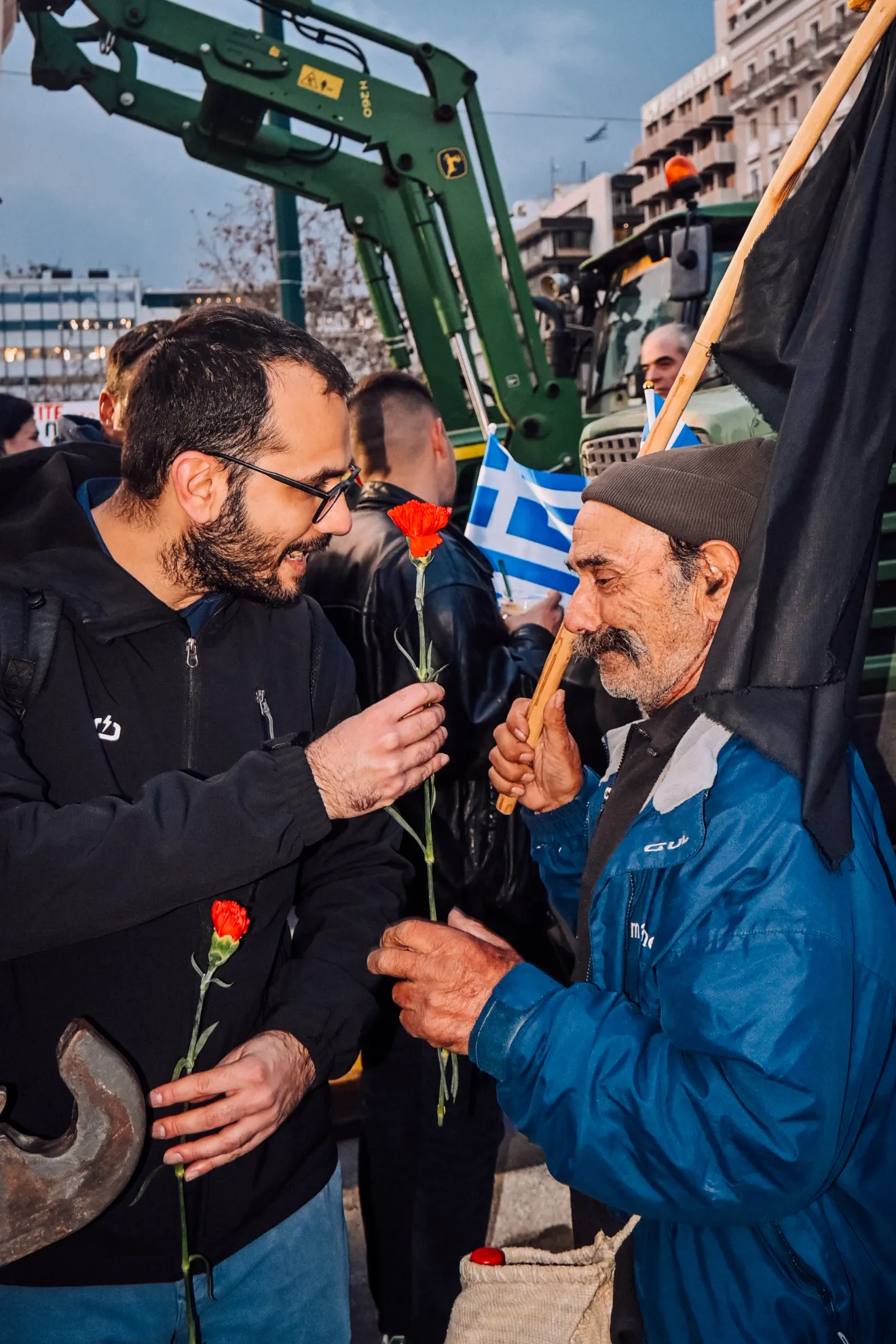 Ένας διαδηλωτής δίνει ένα τριαντάφυλλο σε έναν αγρότη.