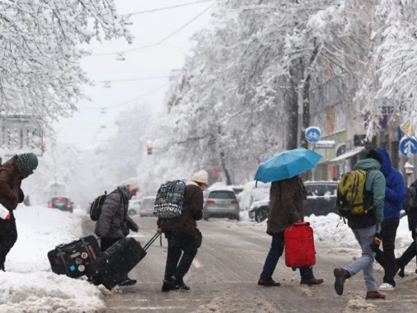 Ταξιδιώτες με τις βαλίτσες τους σε χιονισμένο δρόμο του Μονάχου