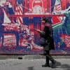 Γυναίκα περνάει δίπλα από μια αντι-αμερικανική τοιχογραφία σε της πρώην πρεσβείας των ΗΠΑ, η οποία χλευάζει τις συνομιλίες Ιράν και Ηνωμένων Πολιτειών