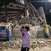 άνθρωποι στέκουν μπροστά από κατεστραμμένο κτήριο σε Βενεζουέλα μετά τον σεισμό