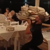 Σερβιτόρος σηκώνει φορτωμένο δίσκο στον έναν ώμο