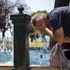 Άντρας δροσίζεται σε σιντριβάνι