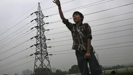 Ένα παιδί δίπλα από κολώνα υψηλής τάσης.