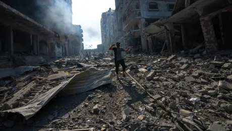 Άνδρας περπατά στα χαλάσματα μετά από βομβαρδισμό στη Γάζα