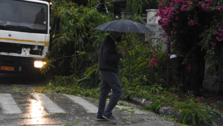 Άνδρας κρατά ομπρέλα και περπατά στη βροχή