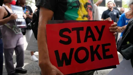 Διαδηλωτής κρατάει πινακίδα "Stay Woke" κατά τη διάρκεια διαμαρτυρίας για το εκπαιδευτικό σύστημα στη Φλόριντα