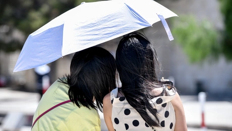 Τουριστριες με ομπρελα κατω από τον καυτο ηλιο