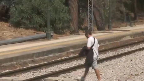 Άνδρας περνάει από τις γραμμές του τρένου