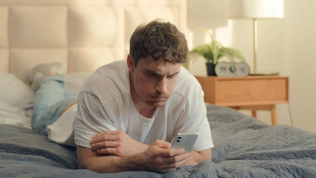 Άνδρας κοιτάζει το κινητό του προβληματισμένος