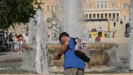 Περαστικός μπροστά από το συντριβάνι του Συντάγματος