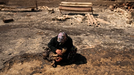 Γυναίκα κλαίει σε χωράφι μετά από φωτιά