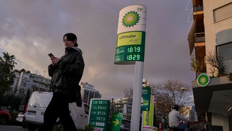 Μια γυναίκα περνάει δίπλα από μια πινακίδα που δείχνει τις τρέχουσες τιμές καυσίμων έξω από ένα βενζινάδικο στην Αθήνα, Ελλάδα, την Τετάρτη 11 Μαρτίου 2026. (AP Photo/Petros Giannakouris)