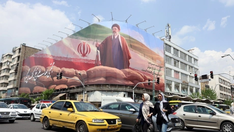 Ιρανοί περνούν δίπλα από μια μεγάλη πινακίδα του Ανώτατου Ηγέτη του Ιράν Αγιατολάχ Μοτζτάμπα Χαμενεΐ σε έναν δρόμο στην Τεχεράνη