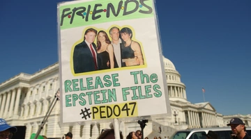 Διαδηλωτές κρατούν πλακάτ για τη φιλία των Ντόναλντ και Μελάνια Τραμπ με τον Τζέφρι Επστάιν και την Γκισλέιν Μάξγουελ